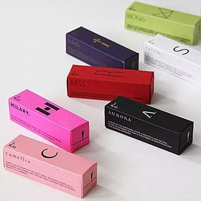 Le panneau en ivoire imprimé polychrome enferme dans une boîte les boîtes blanches de carton de cosmétiques de soin de la peau